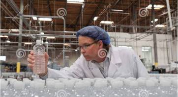 Quality-control-worker-checking-bottled-water-bottling-plant